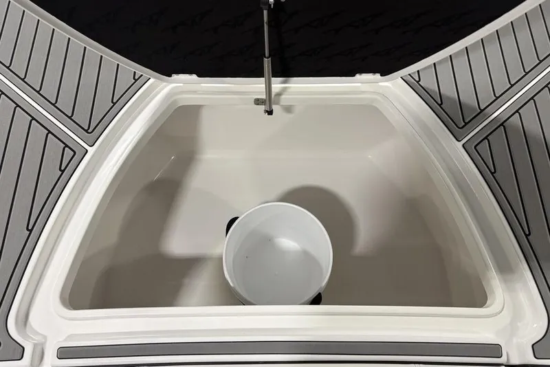 Slide: The Image of 2025 Tidewater 3100 Carolina Bay boat storage compartment with a white bucket inside. - 7