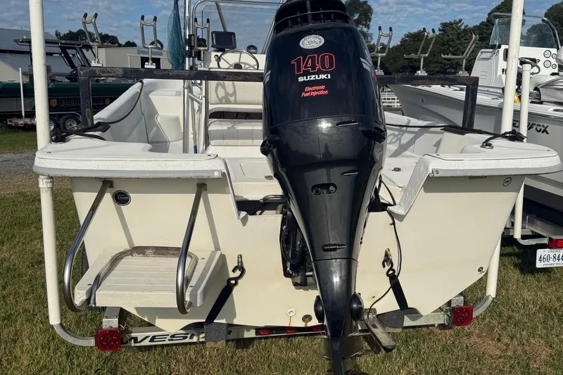 Slide: The Image of 2008 Carolina Skiff 218 DLV with Suzuki 140 outboard motor, parked on grass. - 6
