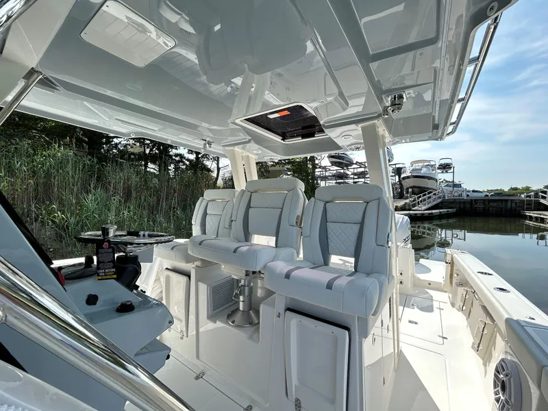 Slide: The Image of 2026 Pursuit S 358 boat interior with luxurious seating and sleek design at a marina. - 14