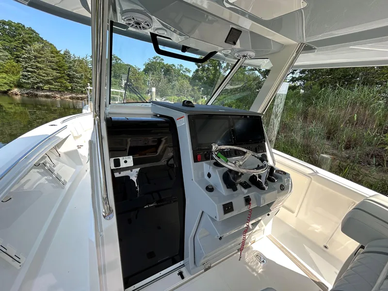 Slide: The Image of 2026 Pursuit S 358 boat cockpit with modern controls and scenic waterway view. - 15