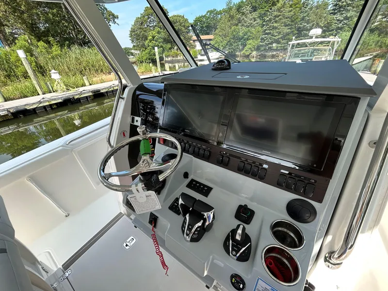 Slide: The Image of Helm of 2026 Pursuit S 358 boat with advanced controls and dual screens. - 16