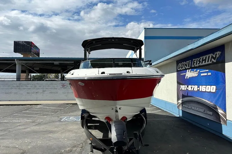 Slide: The Image of 2026 Sea Ray SDX 230 Surf boat on trailer at dealership, sunny day. - 2