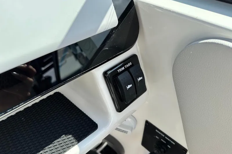 Slide: The Image of 2026 Sea Ray SDX 230 Surf trim tabs control panel close-up. - 26