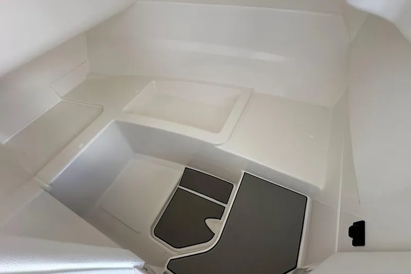 Slide: The Image of Interior view of 2026 Sea Ray SDX 230 Surf boat cabin, featuring sleek white design. - 31