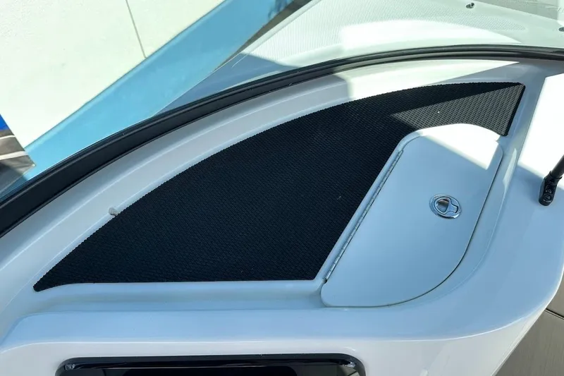 Slide: The Image of 2026 Sea Ray SDX 230 Surf boat dashboard with storage compartment and black mat. - 35