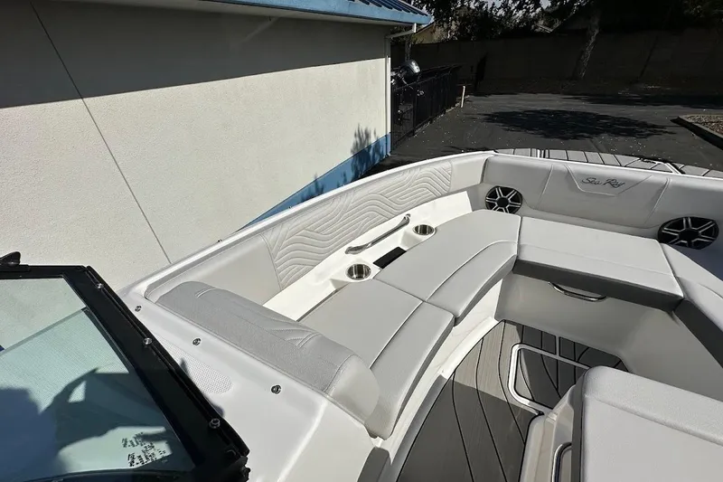 Slide: The Image of 2026 Sea Ray SDX 230 Surf boat interior with white seating and cup holders. - 42