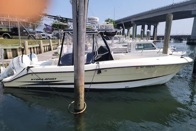 The Image of 2004 Hydra-Sports Vector 2600 CC boat docked near a bridge. - 0