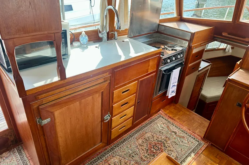 Slide: The Image of 1988 Grand Banks 36 Classic yacht kitchen with wood cabinetry and modern appliances. - 19