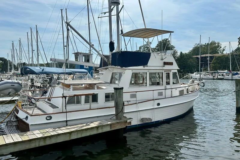 Slide: The Image of 1988 Grand Banks 36 Classic yacht docked at a marina with sailboats. - 2