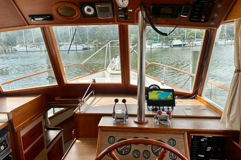 Slide: The Image of 1988 Grand Banks 36 Classic yacht helm with navigation equipment, overlooking marina. - 24