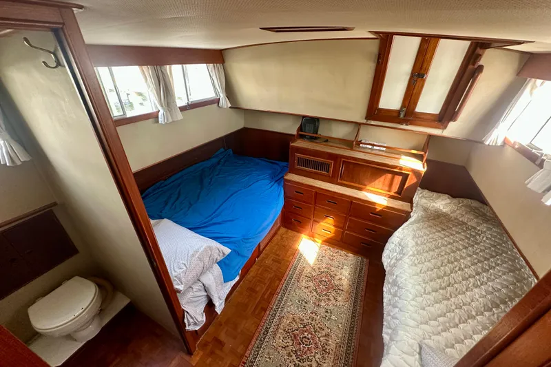 Slide: The Image of 1988 Grand Banks 36 Classic cabin interior with twin beds, wooden cabinetry, and nautical decor. - 35