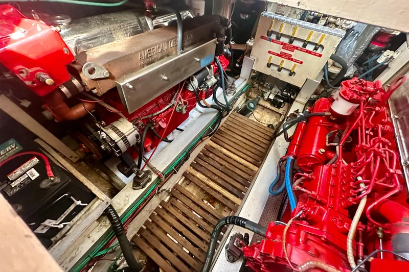 Slide: The Image of Engine room of 1988 Grand Banks 36 Classic with red diesel engines and control panel. - 38
