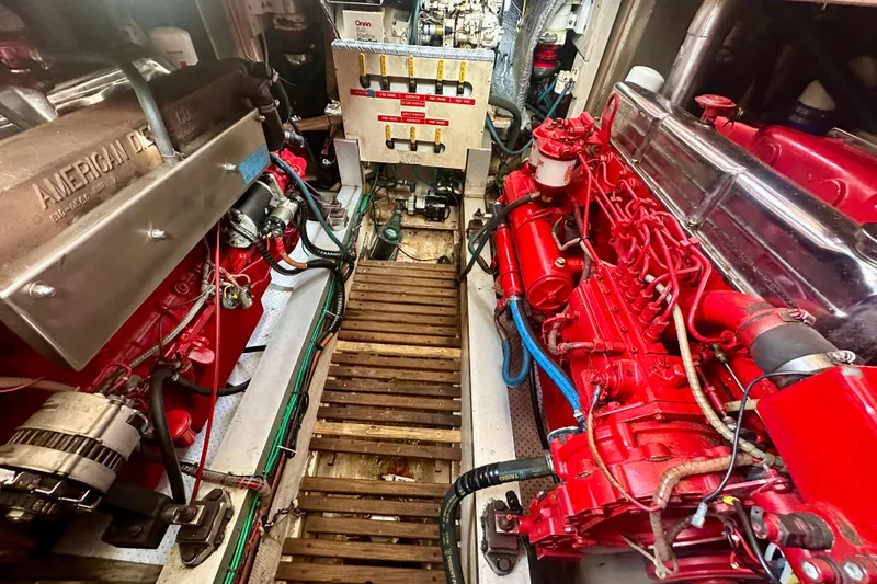 Slide: The Image of Engine room of a 1988 Grand Banks 36 Classic with red machinery and wooden flooring. - 39