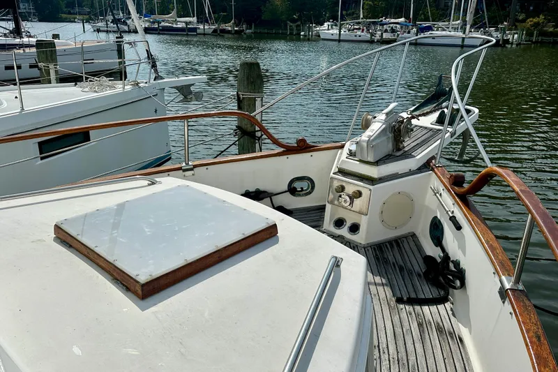 Slide: The Image of 1988 Grand Banks 36 Classic yacht deck with wooden railings and marina view. - 8