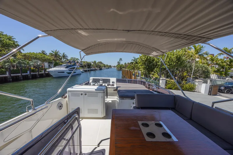 Slide: The Image of 2018 Prestige 520 yacht interior with seating, table, and waterway view. - 34