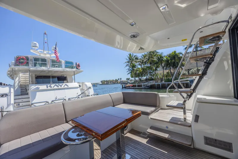 Slide: The Image of Luxury yacht deck with seating area, Prestige 520, 2018 model, docked near palm trees. - 4