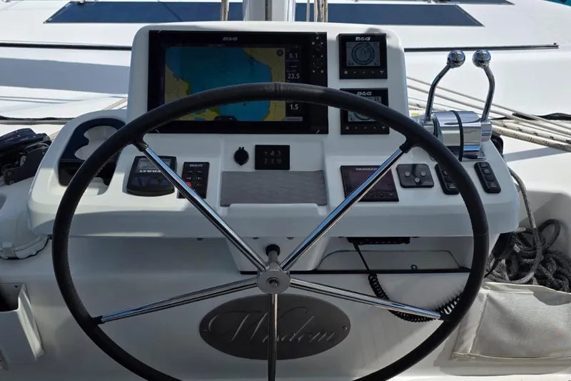 Slide: The Image of 2023 Lagoon 50 yacht helm with navigation controls and steering wheel. - 11