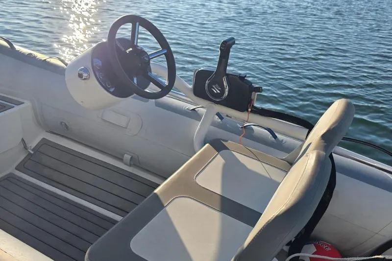 Slide: The Image of Cockpit of 2023 Lagoon 50 boat with steering wheel and control panel on water. - 17