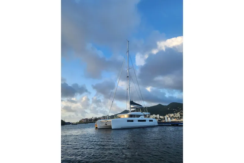 Slide: The Image of 2023 Lagoon 50 catamaran sailing on calm waters under a cloudy sky. - 2