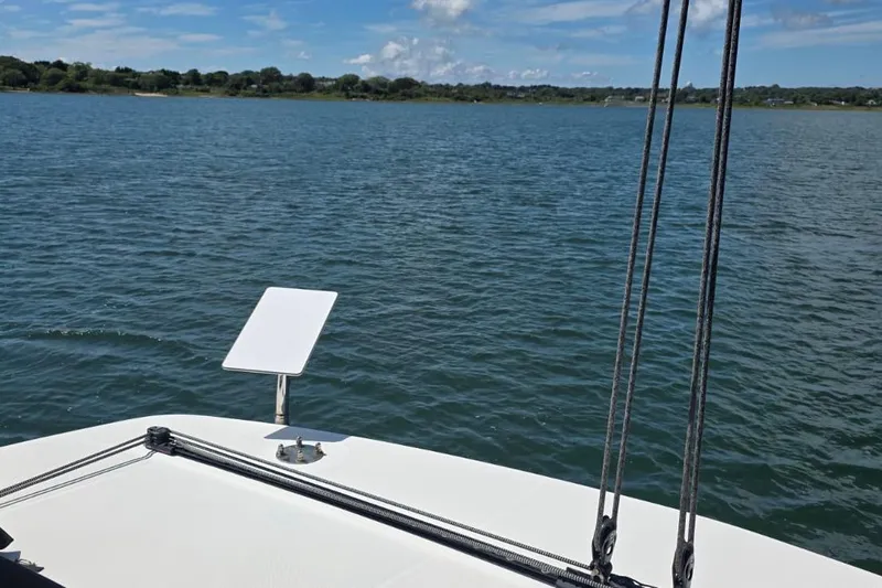 Slide: The Image of 2023 Lagoon 50 catamaran on calm water with clear sky and shoreline. - 21