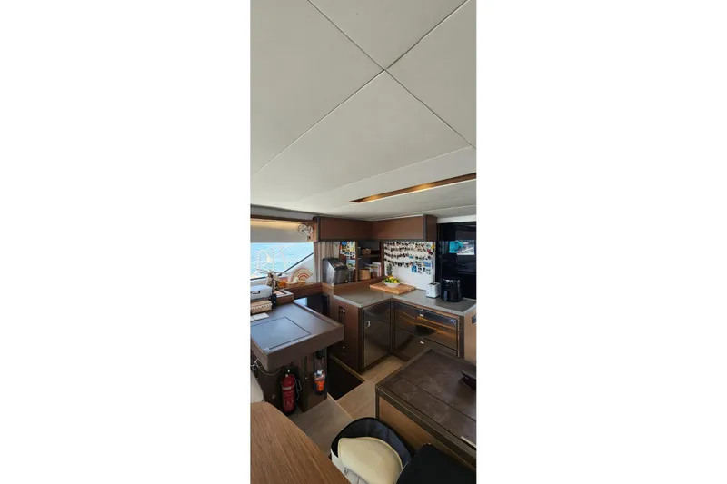 Slide: The Image of Interior of 2023 Lagoon 50 yacht kitchen with modern appliances and ocean view. - 25