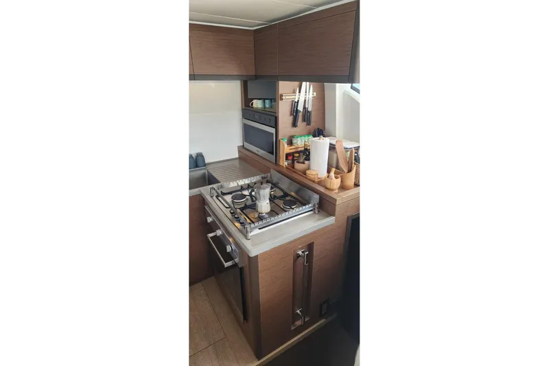 Slide: The Image of Modern kitchen in 2023 Lagoon 50 yacht with stove, sink, and wooden cabinetry. - 33