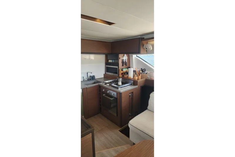 Slide: The Image of Modern kitchen interior of 2023 Lagoon 50 yacht with wooden cabinetry and appliances. - 35