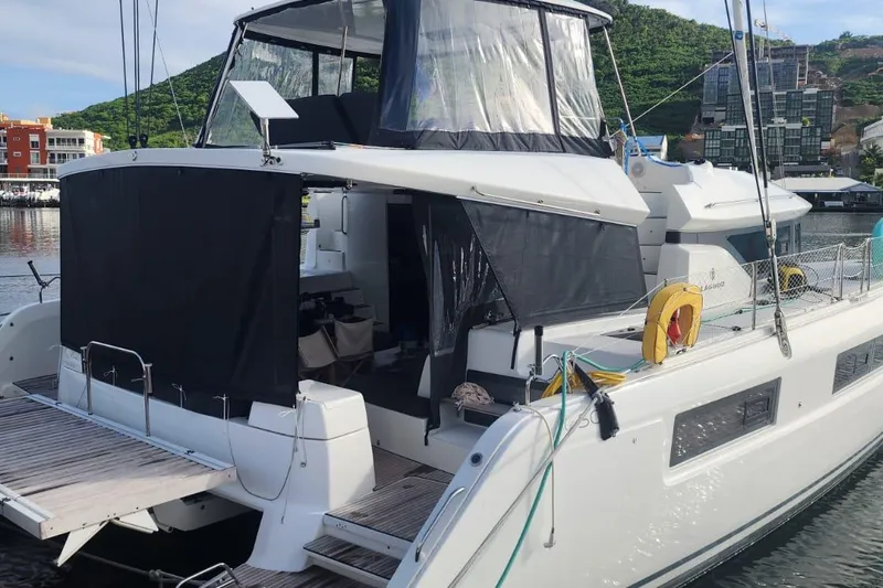 Slide: The Image of 2023 Lagoon 50 catamaran docked in a scenic marina setting. - 5