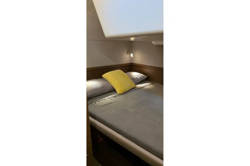 Slide: The Image of Cozy bedroom interior of 2023 Lagoon 50 yacht with modern lighting and yellow accent pillow. - 56