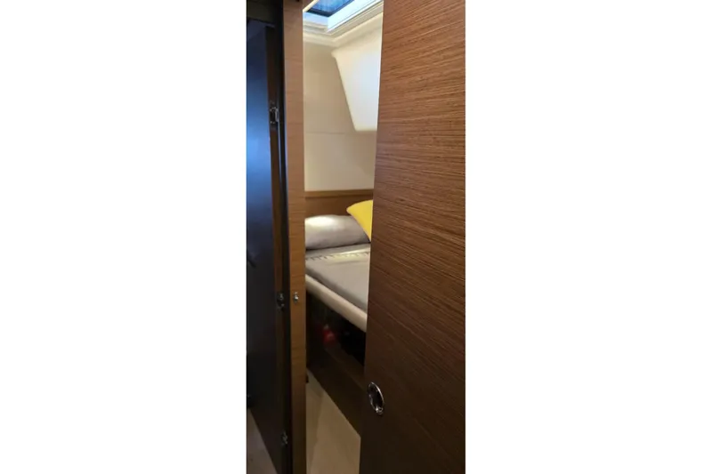 Slide: The Image of Interior cabin view of 2023 Lagoon 50 yacht, featuring a cozy bed and wooden finish. - 57
