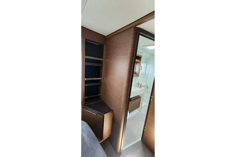 Slide: The Image of Interior of 2023 Lagoon 50 yacht featuring modern wood cabinetry and bathroom. - 59