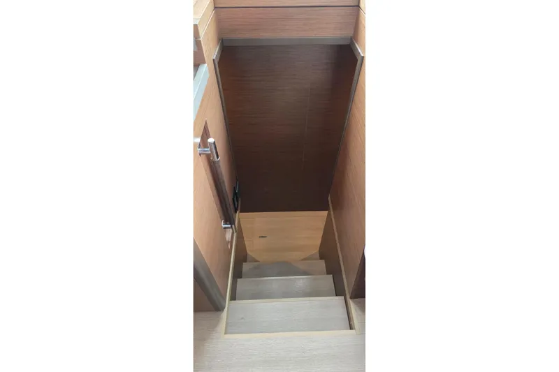 Slide: The Image of Staircase inside 2023 Lagoon 50 yacht, featuring wooden steps and modern design. - 60
