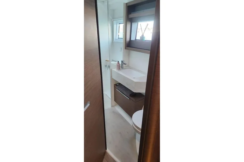 Slide: The Image of Modern bathroom interior on 2023 Lagoon 50 yacht, featuring sleek sink and window. - 69