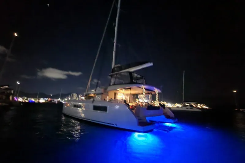 Slide: The Image of 2023 Lagoon 50 catamaran illuminated at night with blue underwater lights. - 87