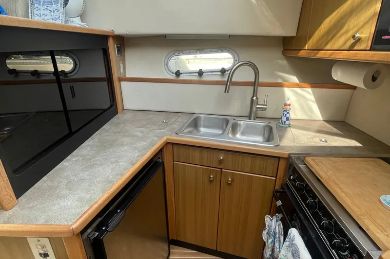 Slide: The Image of 2001 Bayliner 3388 Command Bridge Motoryacht kitchen with sink, stove, and countertop. - 19