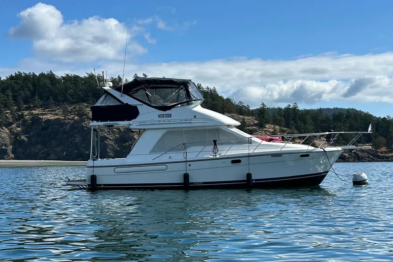Slide: The Image of 2001 Bayliner 3388 Command Bridge Motoryacht on scenic water with forested background. - 2
