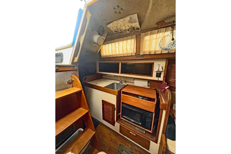 Slide: The Image of 1982 S 2 9.2C sailboat interior with kitchenette and wooden cabinetry. - 3