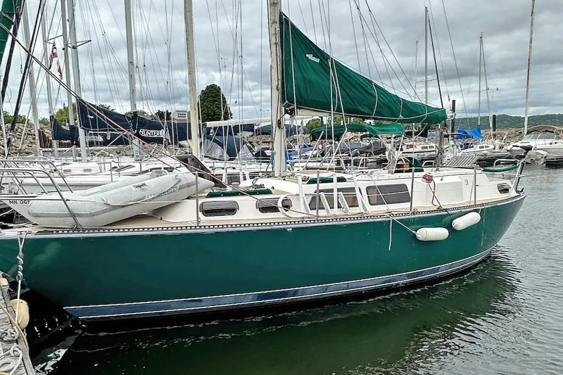Slide: The Image of 1982 S 2 9.2C sailboat docked in marina with green hull and sails. - 9