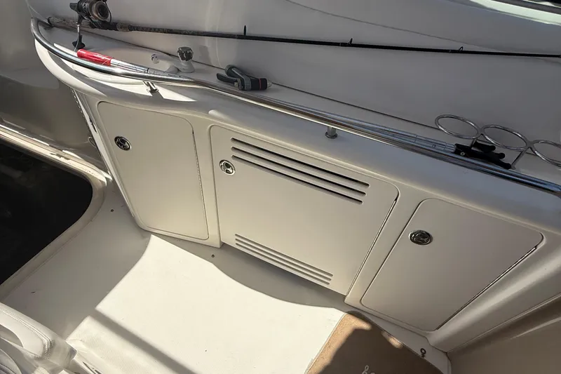 Slide: The Image of 2002 Sea Ray 360 Sundancer cockpit with fishing rod and storage compartments. - 13