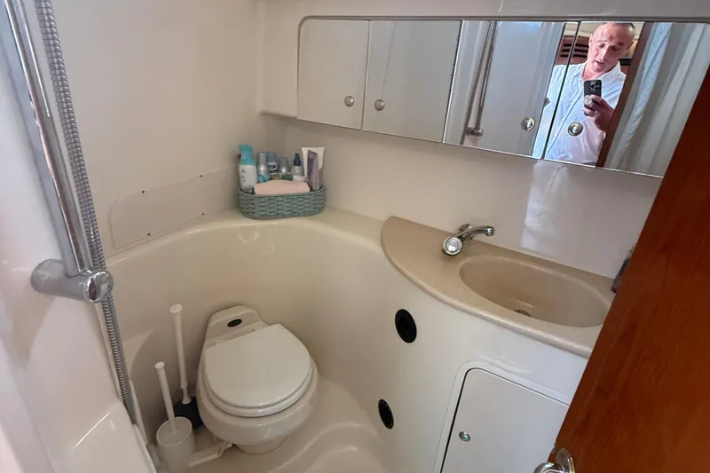 Slide: The Image of Bathroom of 2002 Sea Ray 360 Sundancer with sink, toilet, and mirror cabinet. - 27