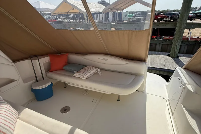 Slide: The Image of 2002 Sea Ray 360 Sundancer interior with cushioned seating and canopy at dock. - 28