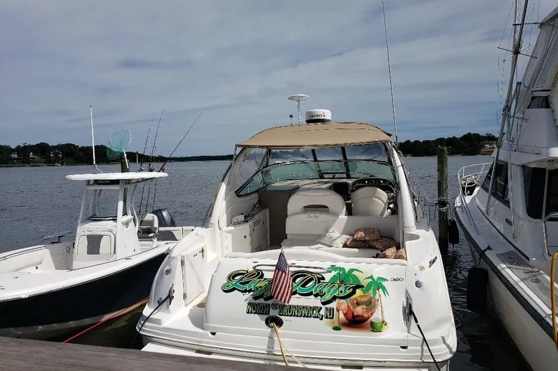 Slide: The Image of 2002 Sea Ray 360 Sundancer docked, featuring a cozy seating area and decorative graphics. - 30