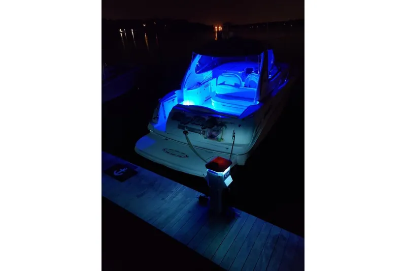 Slide: The Image of 2002 Sea Ray 360 Sundancer with blue interior lights docked at night. - 31
