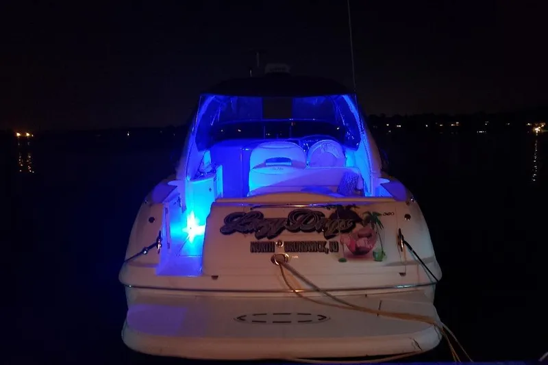 Slide: The Image of 2002 Sea Ray 360 Sundancer yacht with blue interior lights at night. - 32