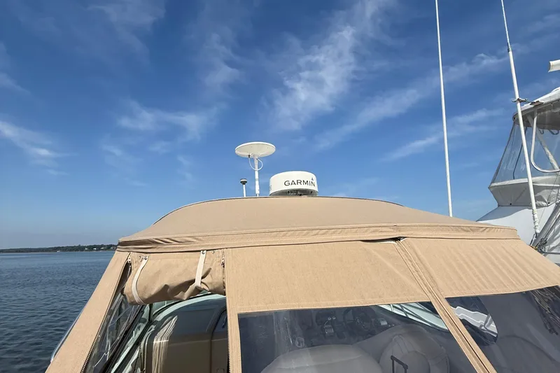 Slide: The Image of 2002 Sea Ray 360 Sundancer with Garmin radar, beige canopy, and clear blue sky. - 5