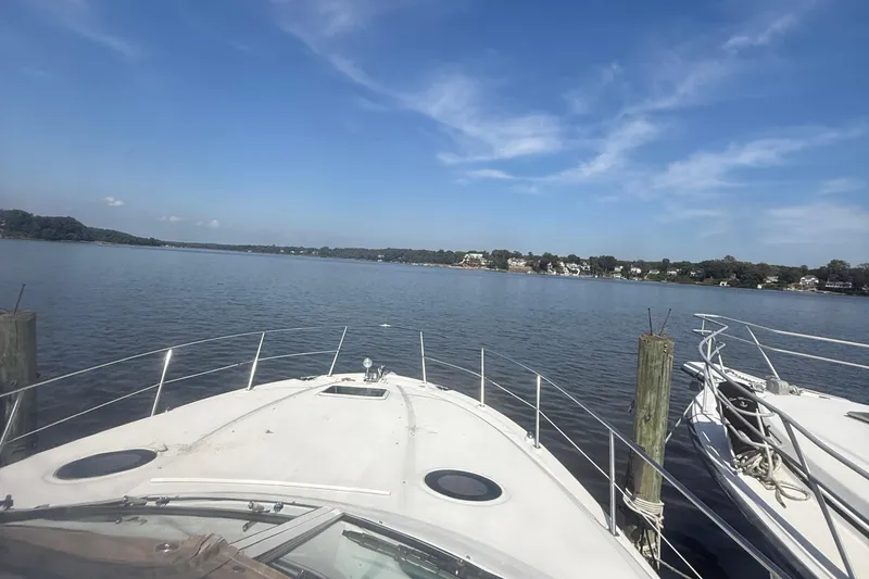 Slide: The Image of 2002 Sea Ray 360 Sundancer yacht docked on a serene lake under a clear blue sky. - 6