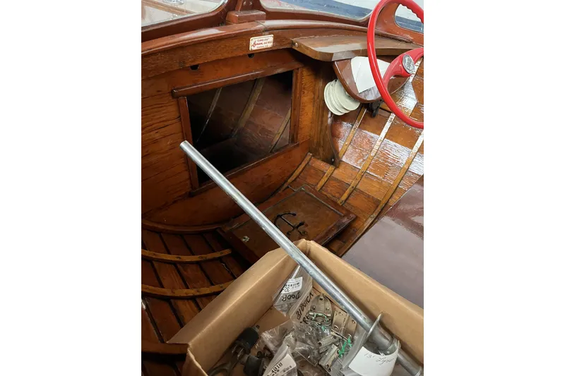 Slide: The Image of 1954 Lyman outboard boat interior with wooden finish and red steering wheel. - 11