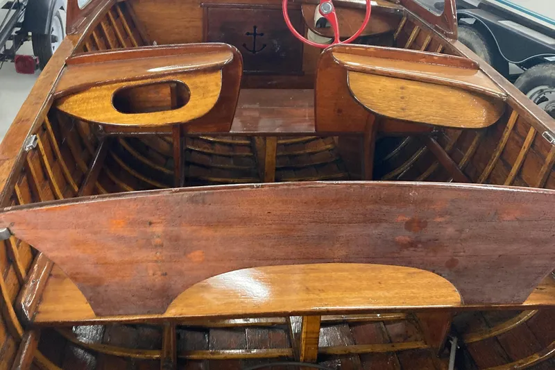 Slide: The Image of 1954 Lyman outboard boat interior with wooden seats and red steering wheel. - 3