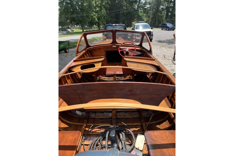 Slide: The Image of 1954 Lyman outboard boat interior with wooden finish and red steering wheel. - 6