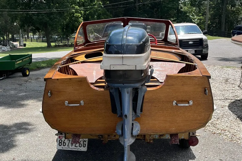 Slide: The Image of 1954 Lyman outboard boat with wooden finish, parked outdoors. - 7